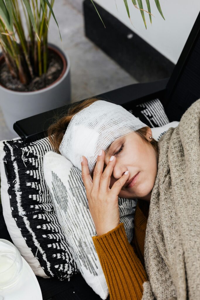 A woman with a head injury rests indoors, showcasing the warmth of a cozy, home environment.